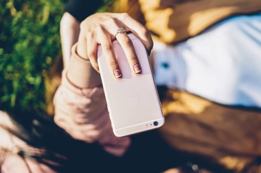 Modern dijital telefon aygıtı tutan ve selfie fotoğrafları açık havada yeşil yalan arkadaşı ile birlikte sosyal ağlar için yapma kadın eli en iyi seçim odak zevk güneşli havalarda çimen