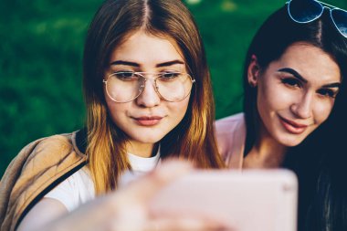 Modern smartphone ön kamera seyir ve sosyal ağlarda yükleme ve birçok getting selfie fotoğraf verme güzel hippi kız arkadaşlarından seviyor. Genç kadın cep üzerinde fotoğraf çekimi
