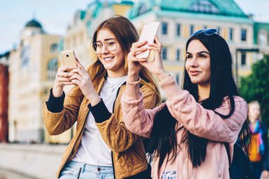 Hayran hipster turist çekim video ve çekici resimler hafta sonu gezisi zevk dijital cep telefonlarında ise new City sokakta geziniyor casual giyim giymiş. Kopyalama alanı alanı metin için