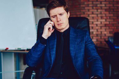 Ciddi bir erkek yöneticinin, telefon görüşmesi sırasında iş arkadaşına danışması, konsantre iş adamı, operatör çek hesabı bakiyesi ile ciddi bir akıllı telefon görüşmesi yapıyor.