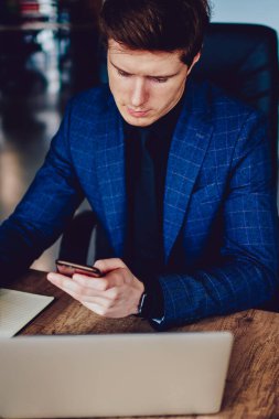 Profesyonel Kafkas erkek direktörü, şirket ofisindeki akıllı telefon aygıtıyla iletişim kurdu. Ciddi bir işadamı, modern cep telefonu yazma verileri üzerinde çalışma zamanını ve organizatörünü kontrol etti.