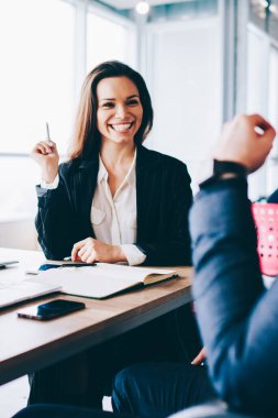 Genç ve neşeli iş kadınının, erkek meslektaşlarıyla kişisel konular hakkında konuşması ve yeni bir başlangıç projesi için fikir alışverişinde bulunmanın keyifli anlarını anımsaması.