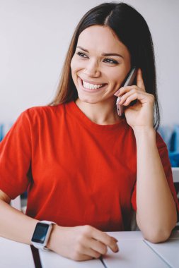 Neşeli bin yıllık hippi kız kafeteryadaki telefon konuşmalarında şakadan gülüyor, akıllı telefon konuşmasından zevk alan mutlu duygusal kadın ve kampüste boş zamanlarında iyi internet bağlantısı.