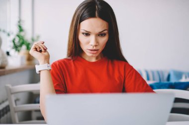 Yoğunlaştırılmış geliştirici, internet alanı için yeni içerik web sitesi için program kodu oluşturma üzerine kafa yoruyor, ciddi kadın serbest çalışan iş ve dizüstü bilgisayarla web sayfasından bilgi almakta zorlanıyor