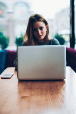 İnternet üzerinden video izlemek için modern netbook kullanan yetenekli bir kadın blogcu, genç bir kadın kafenin içinde çevrimiçi kurslar öğrenirken, dizüstü bilgisayara bağlı, seçici bir odak noktası.