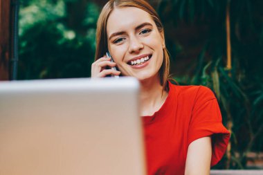 İnternette çalışan gülümseyen kadın yazılım geliştiricisinin portresi Wi-Fi 'ye ve arayan arkadaşına bağlıyken mutlu hippi kız pozitif konuşma sırasında modern netbook' a yeni uygulama yüklüyor.