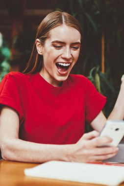 Mutlu hippi kız cep telefonunda indirimlerle ilgili mesajlar alıyor. Kafede oturuyor, içerisi tavan arası, elinde akıllı telefon tutan kadın. Şaşırmış bir ifadeyle.