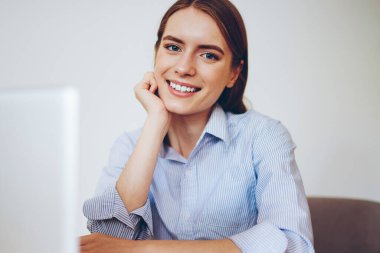 En sevdiği kafeteryada oturan ve yeni modern dizüstü bilgisayarla boş vakit geçiren gülümseyen serbest çalışan kadın portresi. Kapalı alandaki netbook ile uzaktan çalışma sırasında kameraya bakan neşeli hippi kız.