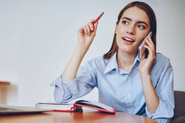 Üniversite kampüsünde oturan ve arkadaşlarıyla cep telefonuyla iletişim kuran, uygulamayı kullanan, modern bilgisayarını evde bırakan çekici yetenekli bir kız öğrenci.