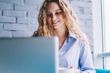 Mutlu bir kadın, internetteki iyi internet üzerinden medya uygulaması ile olumlu videolar izliyor. Neşeli hippi kız, kafede dinleniyor. Modern netbook üzerinden içerik web sayfası için yayın yapıyor.