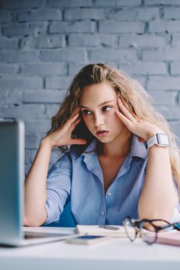 Hüsrana uğramış kadın serbest çalışan, iş yerinde uzaktan çalışma sırasında dizüstü bilgisayardan video izlemekten sıkılmış, mutsuz hippi kız internet üzerinden banka ödemesi yapmakta zorlanıyor.