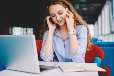 Başarılı kadın serbest çalışan, dizüstü bilgisayarın güncellenmesi konusunda müşteri hizmetlerine danışmanlık yapan, notlar için ders kitabı kullanan, modern akıllı telefon aygıtı ile arkadaşlarıyla iletişim kuran pozitif kadın.