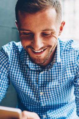 Kafe iç kafe, yakışıklı erkek öğrenci posta cep telefonu molada kontrol büyük iş teklifi alma hakkında mutlu oturma smartphone cep telefonu ile arkadaş sohbet içinde dinlenme neşeli genç adam