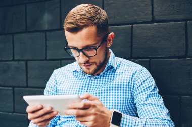 Gözlük online araştırma taşınabilir pc, Finansal Haberler tarama web sayfasında kafede dijital tablet okuma ciddi iş adamı kullanarak proje stratejisi planlama iç yapım genç erkek öğrenci