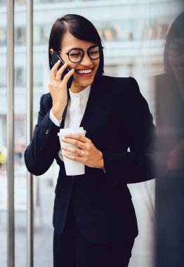 Kahve molası Smartphone'da arkadaşla konuşurken harcama şirketinin müreffeh sahibi portresi. Neşeli işkadını formal giyim açık havada kopyalama alanı alanı yakınında telefon görüşme sırasında gülüyor