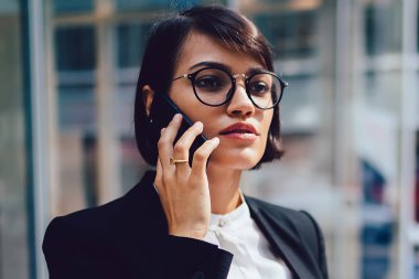 Kendine güvenen kadın gurur CEO'su şık zarif kıyafeti telefon ofis kağıt muhasebe raporları ile Binası yakınındaki aygıt açık havada duran mobil konuşma sırasında mali sorunları çözme