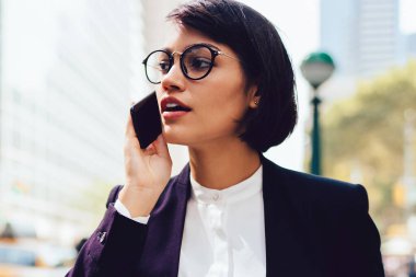 Metropolis'te yürüyüş ve smartphone nea tanıtım alanı üzerinde konuşurken zarif aşınmaya başarılı Finans Müdürü. Telefon konuşmayı kahve holding çalışmaları hakkında işkadını sokağa dön