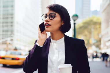 Metropolis'te yürüyüş ve smartphone nea tanıtım alanı üzerinde konuşurken zarif aşınmaya başarılı Finans Müdürü. Telefon konuşmayı kahve holding çalışmaları hakkında işkadını sokağa dön