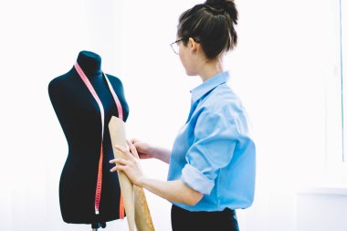 Profesyonel trendy seyir siyah manken yeni örnekleri üzerinde çalışma teyp ile modacı giydirdi. Model oluşturma sırasında aletler kullanarak elbise moda koleksiyonu hakkında düşünme yetenekli kadın terzi