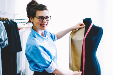 Ünlü tasarımcı popüler şık showroom atelier çalışan dikiş yeni koleksiyonu için siyah manniquin tedbirlerinin yapma gözlük neşeli profesyonel terzi portresi yarım uzunluk