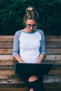 Hippi kız şehirdeki bilgisayar ve internet bağlantılarını kullanarak dışarıda iş yapmayı seviyor. Genç bir kadın sohbet ve sosyal ağlarda paylaşım için internet kullanıyor. Kentteki bankta oturuyor.