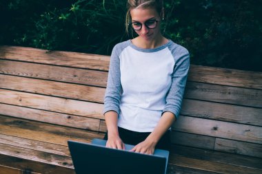 Hippi kız 4 g bağlantısı kullanarak dizüstü bilgisayar ve dizüstü bilgisayar bankta, şehirde serbest zaman harcama sosyal ağlarda arkadaşlarınızla sohbet genç kız öğrenci dinlenme geribildirim yazarak