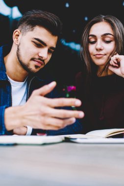 Düşünceli erkek ve kadın öğrencilerin sosyal ağ smartphone aygıt üzerinde içerik izlerken genç hippi çift kafede otururken cep telefonu üzerinden internet Webinar video izleme sahip