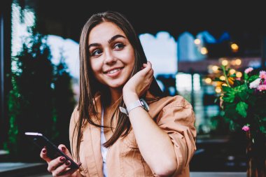 Mutlu genç kadın manifatura iletileri kafe iç giyim serbest zaman sırasında smartphone kullanarak sosyal ağlar sohbet içinde şirin hippi kız gülümseyerek Wi-Fi erişimi ile mobil oturan