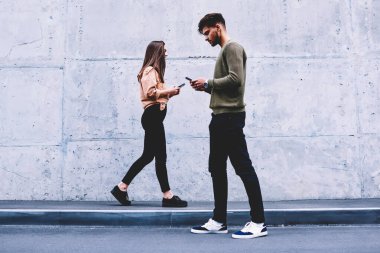 Erkek ve dişi hipsters birbirimizi görmezden gri duvar arka plan üzerinde yürüme tercih sosyal ağlar, sohbet online pon tanıtım alanı geziniyor gerçek hayatta iletişim yerine öğrenciler