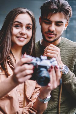 Şirin hippi kız holding vintage fotoğraf makinesi fotoğraf, donanım sorunlarını çözmek için amatör soran erkek fotoğrafçı arkadaş yapmak için ayarlar yapmak onun erkek arkadaşı ise portresi