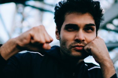 Motive genç spor formu ve canlılık korumak için kentsel ortamda boks eşofman giymiş adam yerleştirmek. Elele yüz yakın ve sıcak sırasında egzersizleri yaparken etkin aşınmaya ciddi sporcu