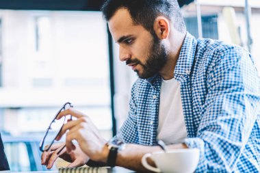 Erkek grafik tasarımcısı kullanarak uygulama iş dizüstü bilgisayarda çevrimiçi dosya indirme ağlarından office coworking oturan netbook okuyan adam serbest üzerinde çalışma için konsantre