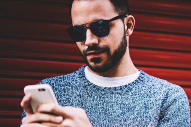 Kentsel ayarları arka plan, serbest zaman açık havada harcama hücresel güncelleştirme uygulama bildirimini kontrol hipster adam akıllı telefon ayakta gönderen metin iletisi sohbet yakışıklı genç adam