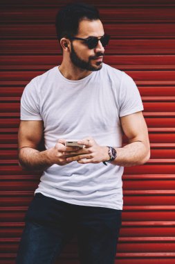 Yakışıklı adam rahat giyim smartphone Ağ kentsel promosyon arka plan yakınında sokakta vakit genç hipster adam açık havada için telefon kullanarak bloglama dinlenme upload fotoğraf