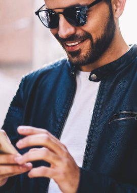 Kırpılmış görüntü gülümseyen adam gelir çıkıyor sokak, neşeli genç üzerinde cep telefonunda e-posta erkek iyi haber alma geribildirim olarak sosyal ağlar açık havada sohbet smartphone üzerinden gönderme