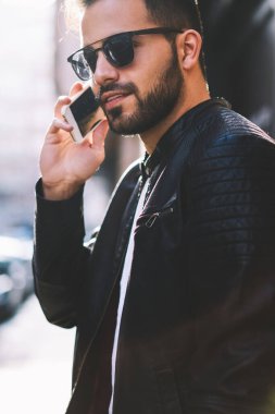 Yakışıklı erkek trendy giyim ucuz tarifeler şehir caddede yürüyüş sahip cep telefonunda genç konuşuyor'hipster adam telefon konuşma bir arkadaşım harcama zaman açık havada gezici