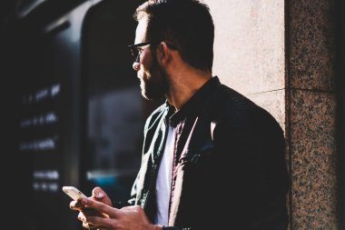 Genç erkek kişi uzak Caddesi üzerinde şehir sokak, hipster adam metin sohbet mesaj online telefon açık havada duran üzerinden gönderme üzerinde doğru yönde seçtiğiniz için smartphone uygulama kullanarak arıyorum