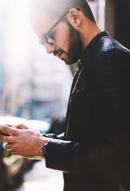 Gelir kısa mesaj okuma ve açık havada, genç erkek 4 g Internet ağ şehir sokak üzerinde bağlı telefon online video izlerken ayakta smartphone üzerinden geri göndermeye dalgın hipster adam