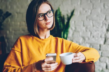 Yeni iş fikri üzerine düşünme meslektaşım telefon sms mesaj coworking kahve molası sırasında alınan süre uzağa arıyorsunuz gözlük kafede düşünceli emin sahibi