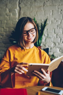 İlginç roman kafede hobi zevk dinlenme okuma Eyewear dalgın gülümseyen genç kadın. Sınava hazırlık rahat kafede serbest zaman harcama elinde kitapla çekici öğrenci