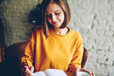 Rüya gibi genç kadın gelecek planları ve hedefleri kendi günlüğü rahat kafeteryada lezzetli cappucino bardak ile dinlenme aşağı yazma. Not Defteri'nde yazarken iyi fikir almak yapım gülümseyen hippi kız
