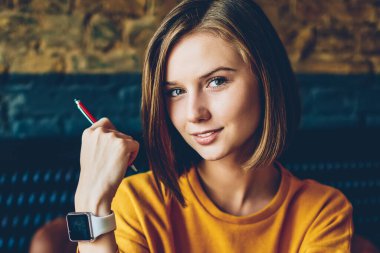 Yarım uzunluk portre çekici yaratıcı öğrenci dizüstü bilgisayar mesafe iş sırasında kameraya seyir. Bilgisayarda yeni grafik tasarımı kısa saç kesimi olan güzel kadın