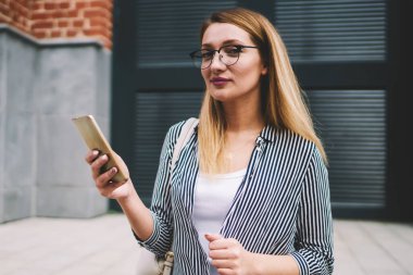 Kafkasyalı genç bir kadın kameraya bakıyor. Elinde yeni akıllı telefonuyla bekleyen bir arkadaş. Moda elbisesi içinde tasasız, güzel bir yeniyetme kız.