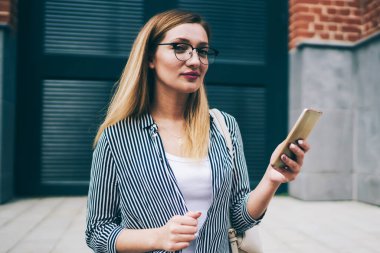 Kafkasyalı genç bir kadın kameraya bakıyor. Elinde yeni akıllı telefonuyla bekleyen bir arkadaş. Moda elbisesi içinde tasasız, güzel bir yeniyetme kız.