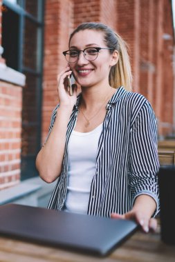 Gülümseyen başarılı kadın metin yazarı, cep telefonuyla iletişim kurarken uygulama ve Netbook ile uzaktan çalışmanın keyfini çıkarırken 4G bağlantısı kullanıyor.