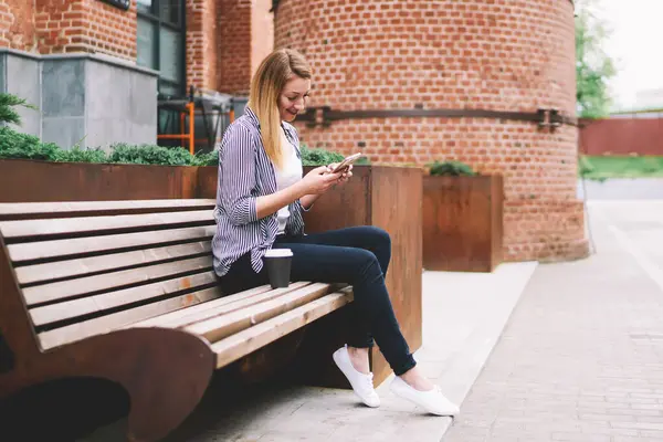 Neşeli beyaz kadın, 20 'li yaşlarda, elinde modern akıllı telefon, açık havada 4G bağlantısı olan, sosyal ağda iyi haberler okuyan, günlük giyinmiş, pozitif hippi kız, yeni cep telefonu kullanıyor.