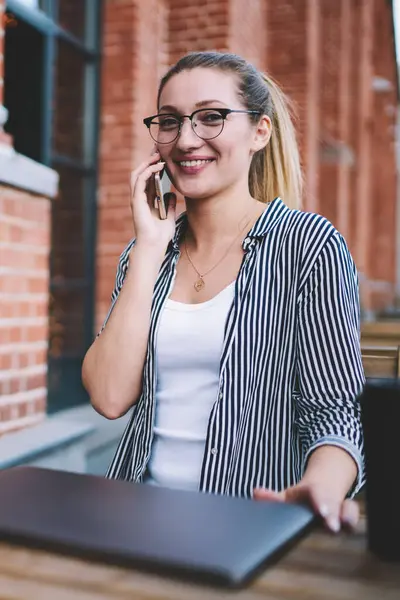 Gülümseyen başarılı kadın metin yazarı, cep telefonuyla iletişim kurarken uygulama ve Netbook ile uzaktan çalışmanın keyfini çıkarırken 4G bağlantısı kullanıyor.