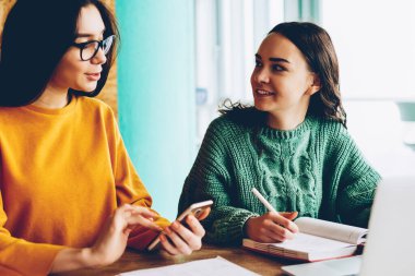 İki arkadaş sosyal ağlar masaüstü dizüstü bilgisayar ile oturup son haberler tartışmaya bağlı 4 g kablosuz internet. Genç kadın netbook Üniversitesi'nde oturan proje hakkında iletişim