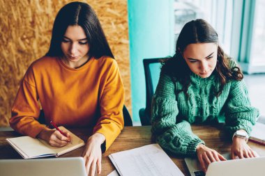 Yetenekli Öğrenciler üniversite iç oturan modern netbook, ödev. Dijital dizüstü bilgisayar uzaktan çalışmak için yüksek hızlı 4 g internet bağlantısı kullanan akıllı kadın tasarımcıları