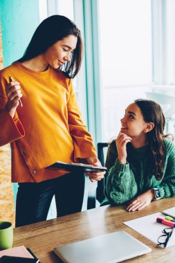 Ofis iç tatilinde yeni başarılı çalışma planı tartışmaya neşeli şık kadın tasarımcılar. Pozitif öğrenciler universitysitting vasıl okul sırası dizüstü bilgisayar ile dostça sohbet